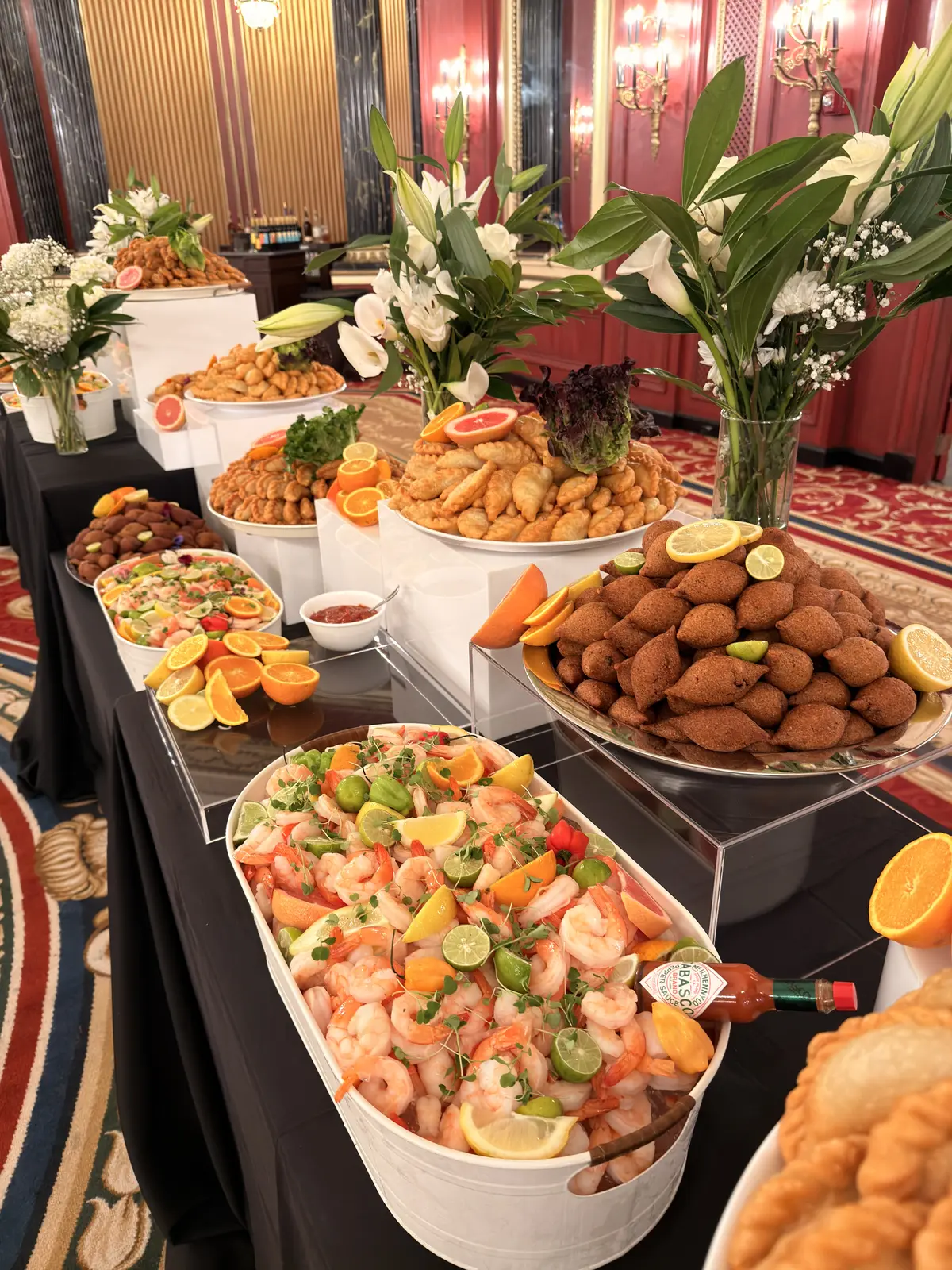 Noosh Catering tiered buffet with fried kibbeh, shrimp cocktail and white calla lilies.