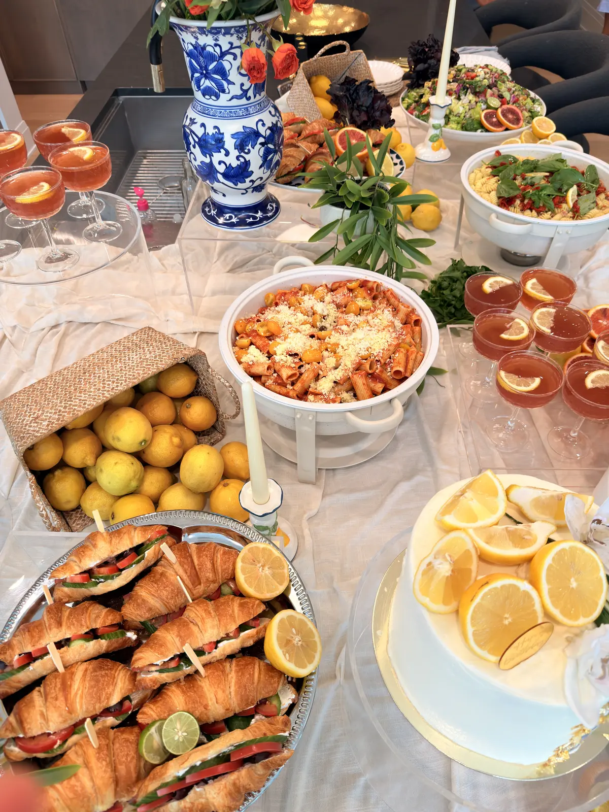 Noosh Catering grazing display with baked pasta, croissant sandwiches, fresh lemons and cocktails.