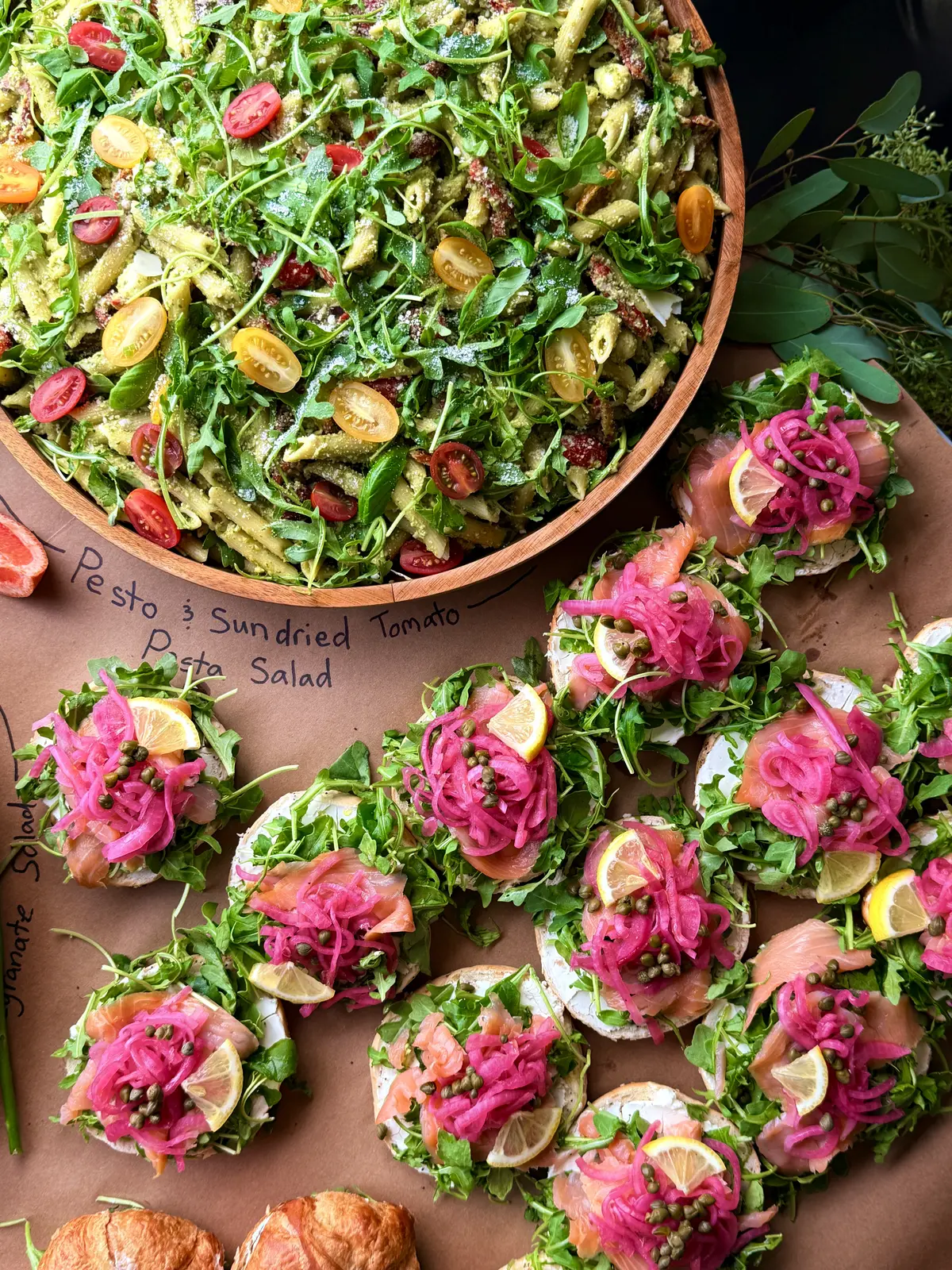 Noosh Catering pesto and sundried tomato pasta salad served in a wooden bowl.